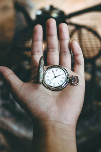 Close-up of hand holding pocket watch