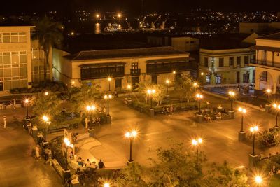 High angle view of illuminated street amidst buildings at night