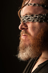 Portrait of man wearing hat against black background