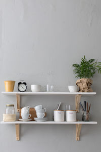Utensils and mugs on shelf