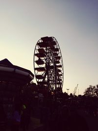 Silhouette ferris wheel against clear sky