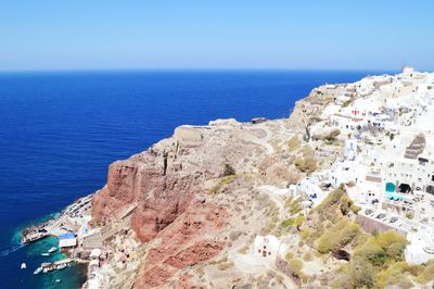 High angle view of townscape by sea against clear sky