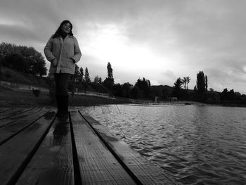 Woman standing on shore against sky