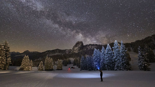 Scenic view of snow covered landscape against star field