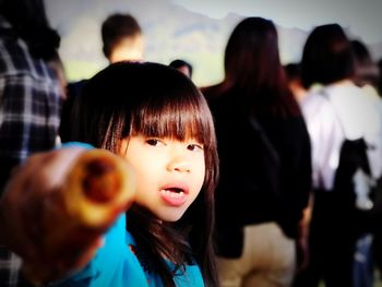 Portrait of smiling girl with people in background