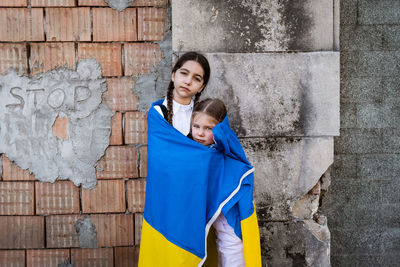Portrait of girls in ukrainian flag against wall