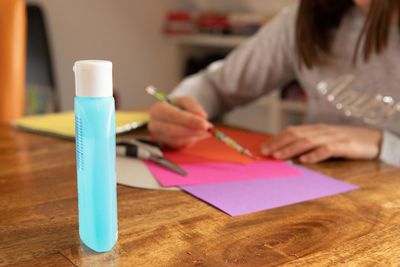 Midsection of woman holding paper with text on table
