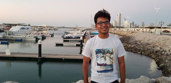 Portrait of young man standing against sea