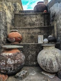 Close-up of old pot against stone wall