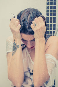 Portrait of woman with umbrella in bathroom