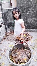 Full length of cute girl standing against wall