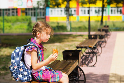 Side view of a girl sitting outdoors