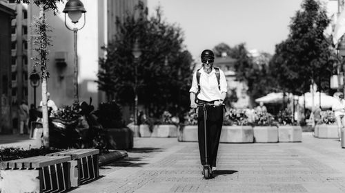 Electric transportation, electric scooter. businesswoman with helmet driving to work in the city.