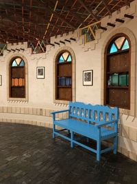 Empty chairs and tables against building