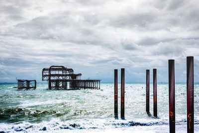 Lifeguard hut on beach against sky during winter