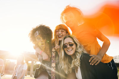 Cheerful friends enjoying in musical festival during sunny day