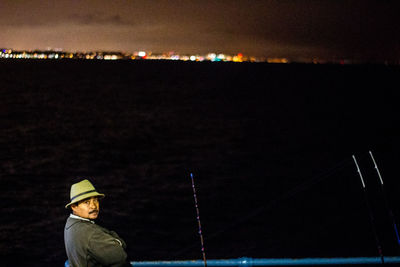 Portrait of man standing against illuminated sky at night