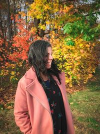Young woman standing in park during autumn