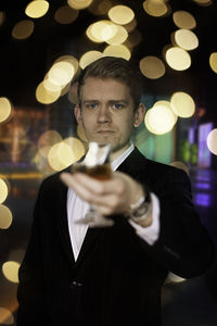 Portrait of young man holding drink glass