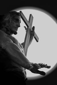 Low angle view of man holding cross