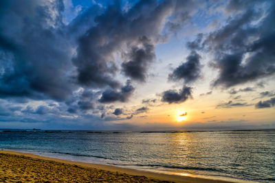 Scenic view of sea against dramatic sky during sunset