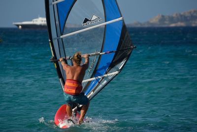 Man in boat on sea against sky