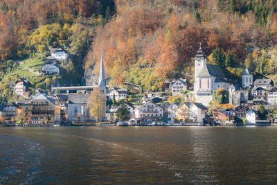 Buildings by lake in town during autumn