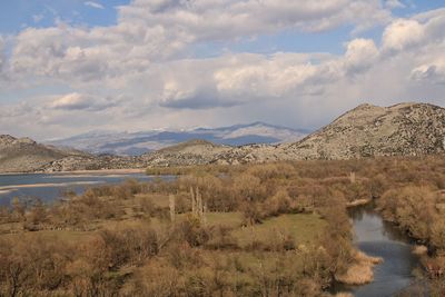 Scenic view of lake and mountains against sky