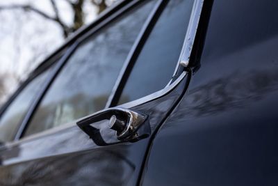 Close-up of sunglasses on car against sky