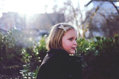 Portrait of girl against trees