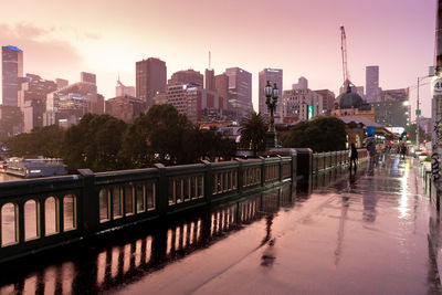 Canal amidst buildings against sky during sunset