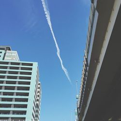 Low angle view of building against bridge against sky