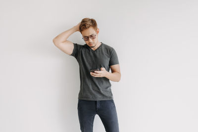 Portrait of young man standing against white background