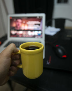 Close-up of hand holding coffee cup