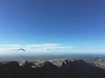 Seagull flying over sea against blue sky