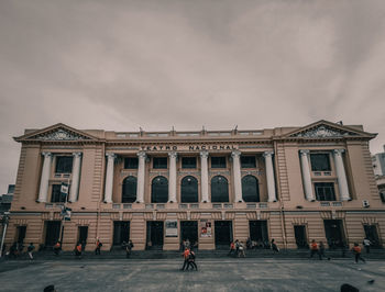 People on street against building in city