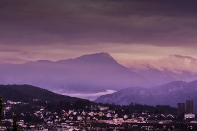 View of cityscape against cloudy sky