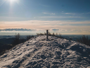 Scenic view of snow covered field against sky