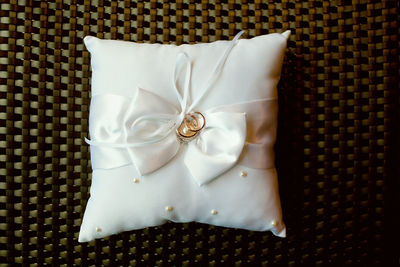 Directly above shot of engagement rings on pillow