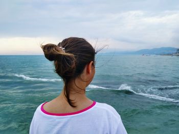 Rear view of woman looking at sea against sky