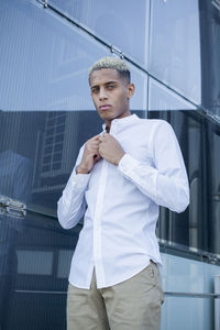 Portrait of young man standing in city