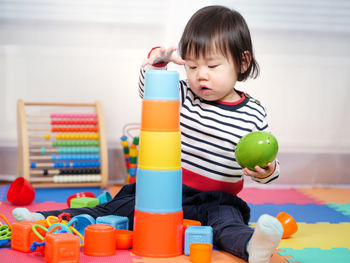 Girl playing with colorful toys at home