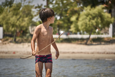 Full length of shirtless boy on beach