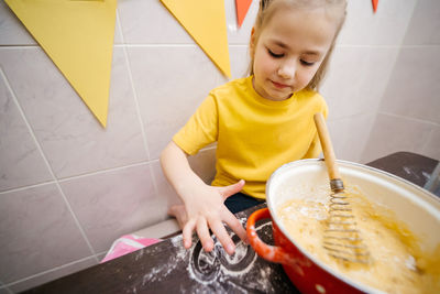 Girl draws a heart with flour, kneads dough for sweets