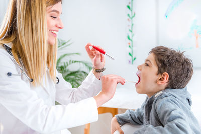 Female doctor examining boy at clinic