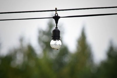 Close-up of electric lamp against sky