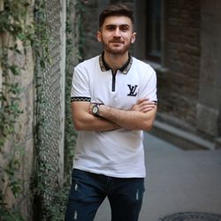 Portrait of young man standing against wall