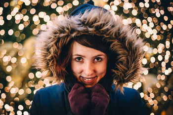 Portrait of young woman with illuminated lights at night