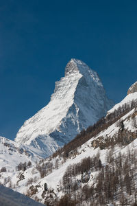 Scenic view of snowcapped mountains against clear blue sky