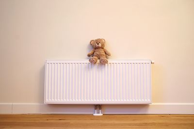 Teddy bear on radiator at home